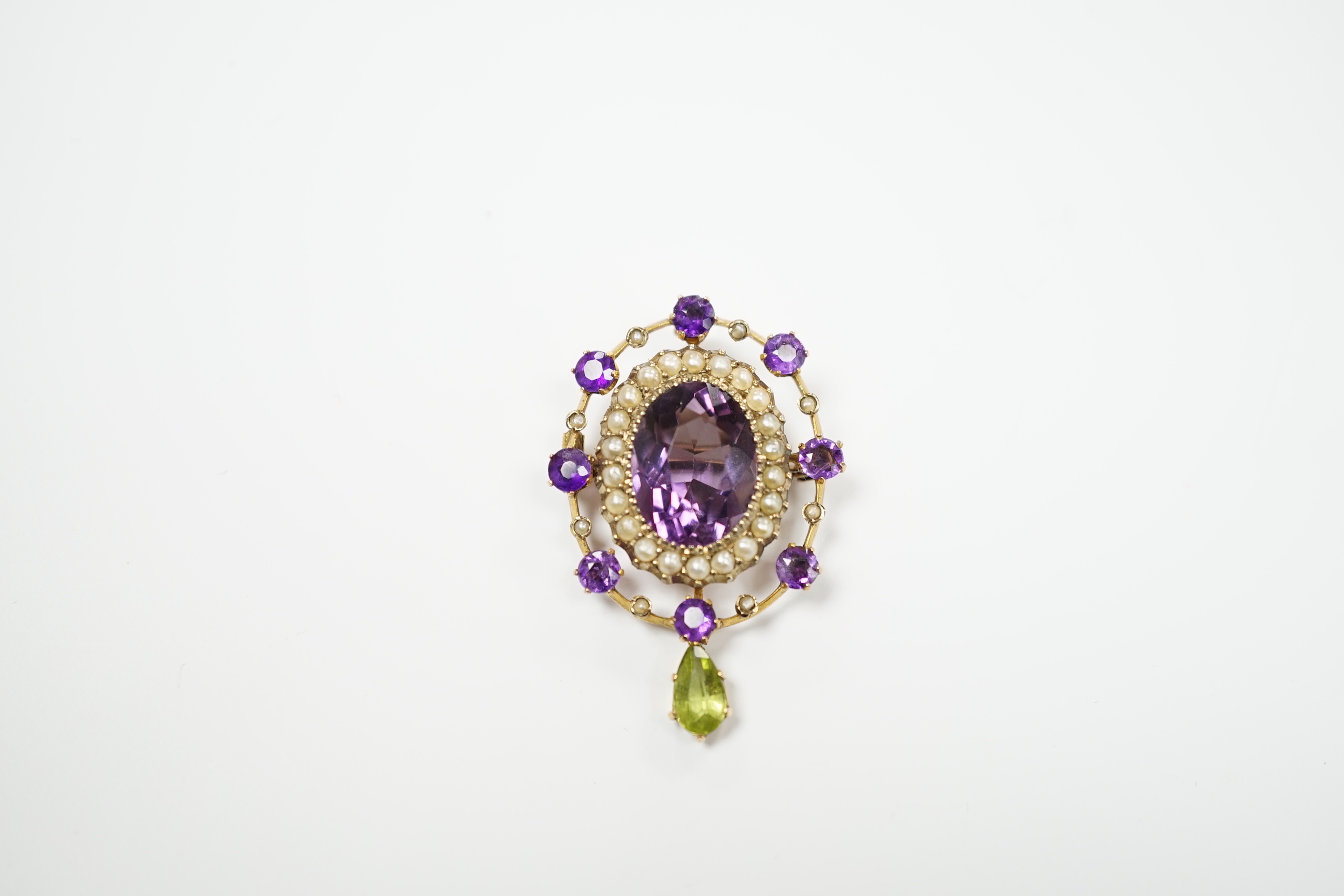 An early 20th century yellow metal, amethyst, peridot and seed pearl cluster set drop pendant brooch, 35mm, gross weight 4.9 grams.